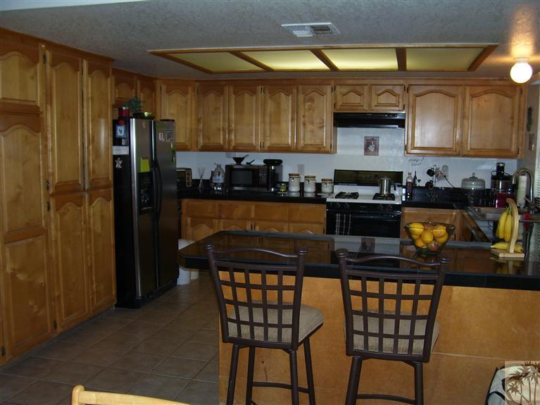 68325 Encinitas Road Cathedral City, CA 92234 - Photo 9 of 20 a kitchen with stainless steel appliances granite countertop a stove a refrigerator a sink a dining table and chairs