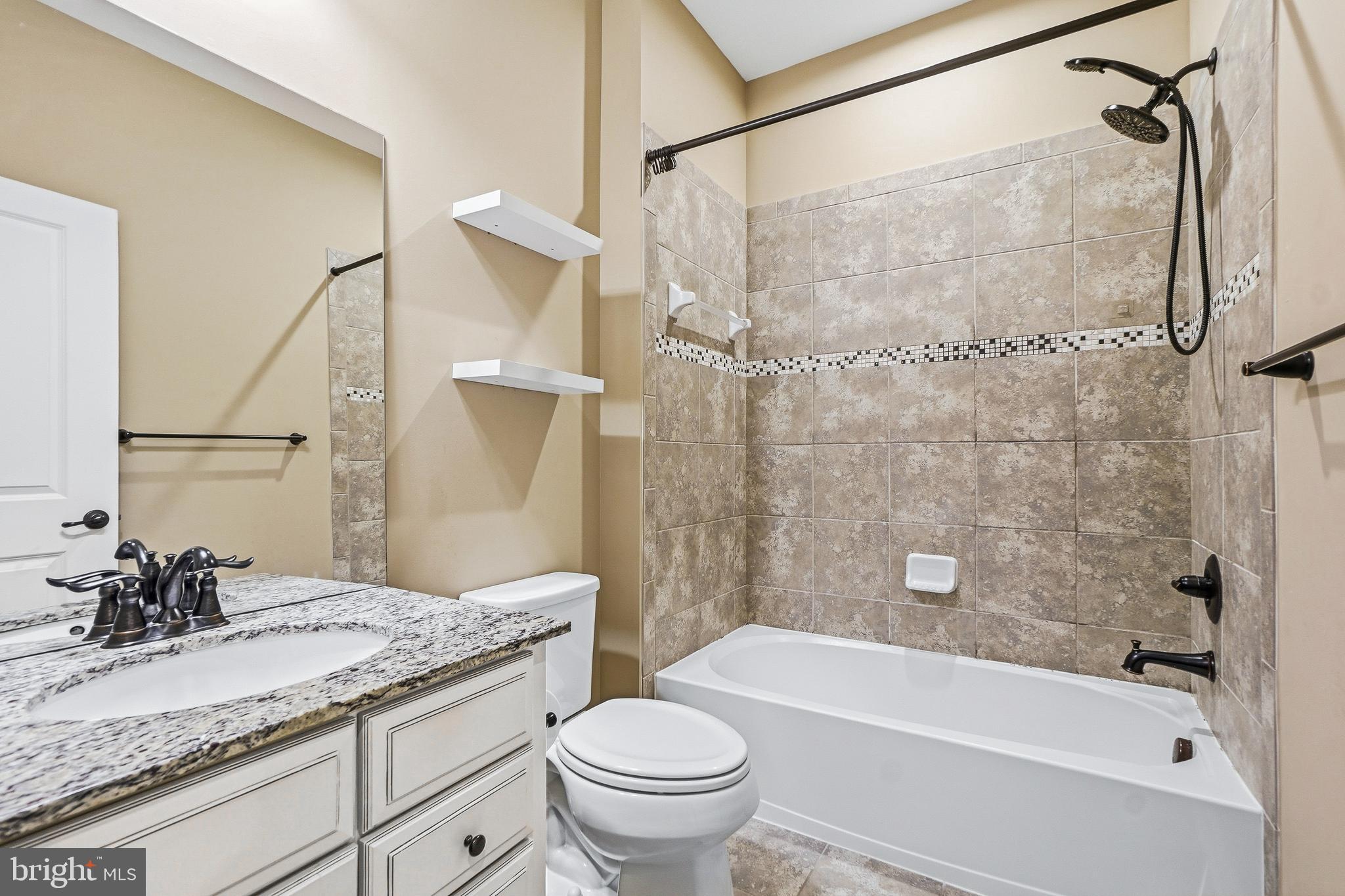 2011 Serviceberry Road Dumfries, VA 22026 - Photo 19 of 25 a bathroom with a granite countertop sink a toilet and shower