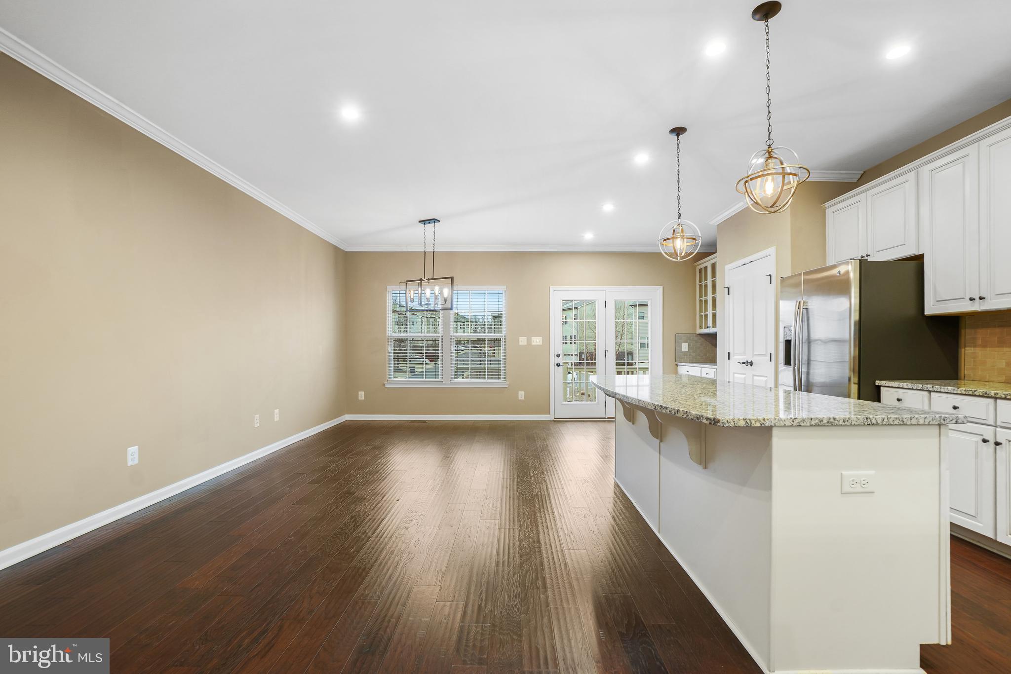 2011 Serviceberry Road Dumfries, VA 22026 - Photo 5 of 25 a view of a kitchen with kitchen island a sink wooden floor and a large window