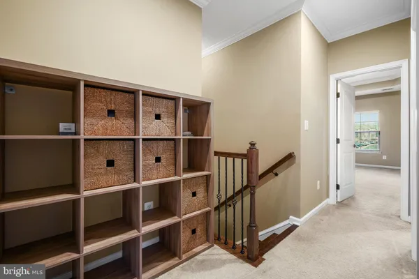 a view of a hallway with wooden floor and a cabinet