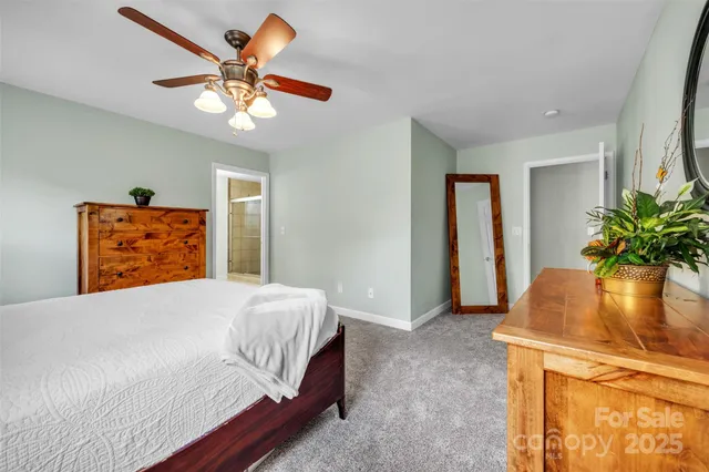 a bedroom with a bed and a potted plant on the dresser
