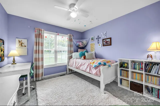 a bedroom with a bed a book shelf and a window