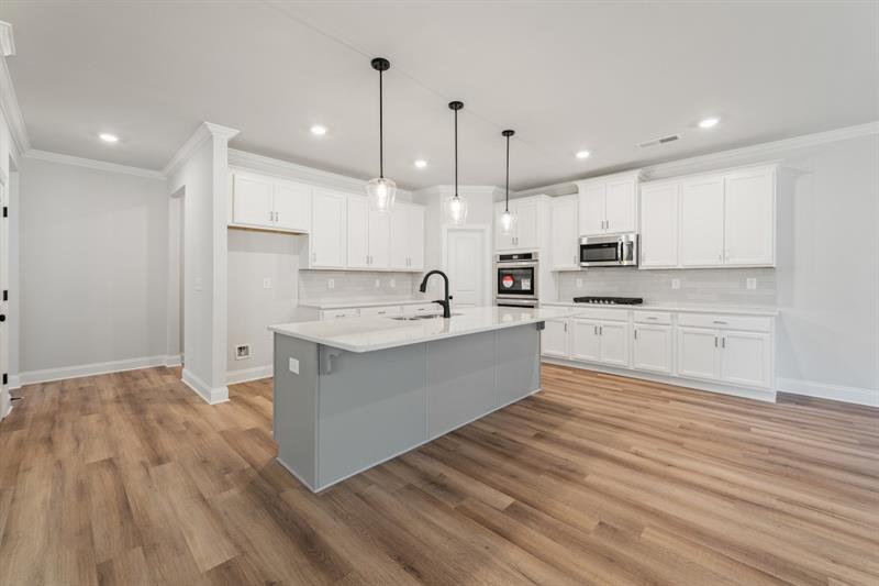3264 Lions Ruby Lane Atlanta, GA 30349 - Photo 11 of 29 a large kitchen with kitchen island a sink stainless steel appliances and cabinets