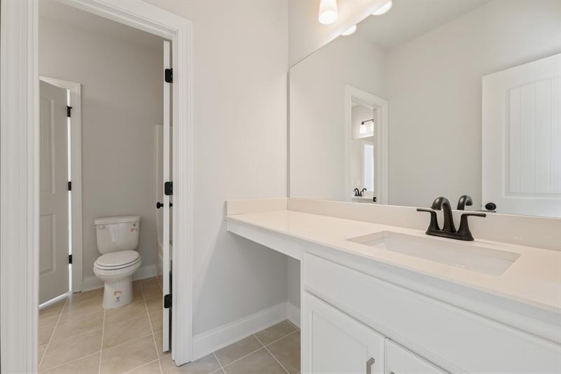 3264 Lions Ruby Lane Atlanta, GA 30349 - Photo 14 of 29 a bathroom with a sink a toilet and a mirror