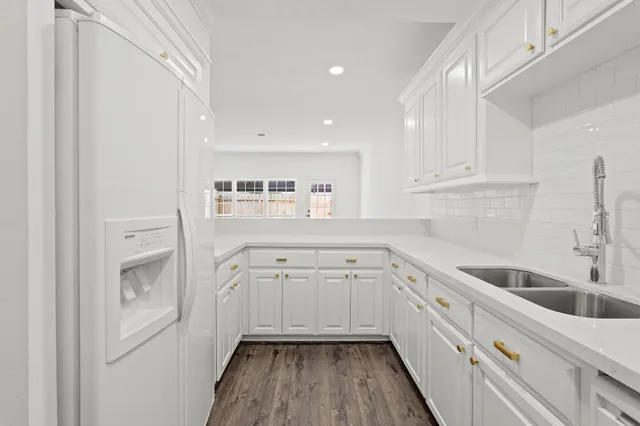 a kitchen with granite countertop white cabinets and white appliances