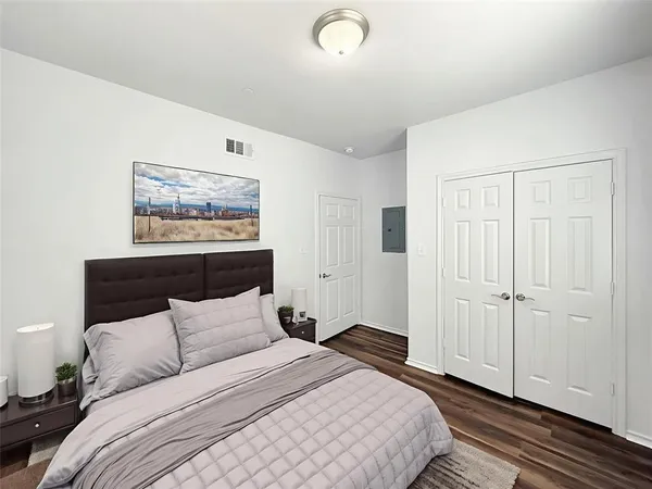 a bedroom with a bed and a painting on the wall