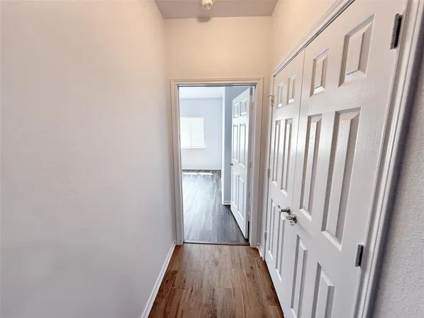a view of a hallway with wooden floor and staircase