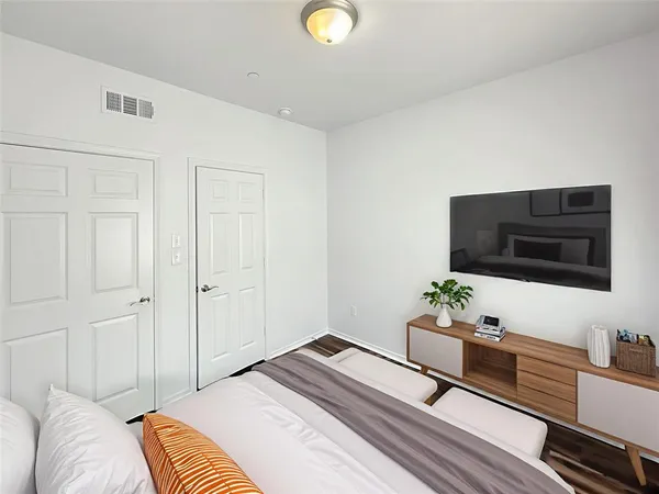 a bedroom with a bed and a potted plant