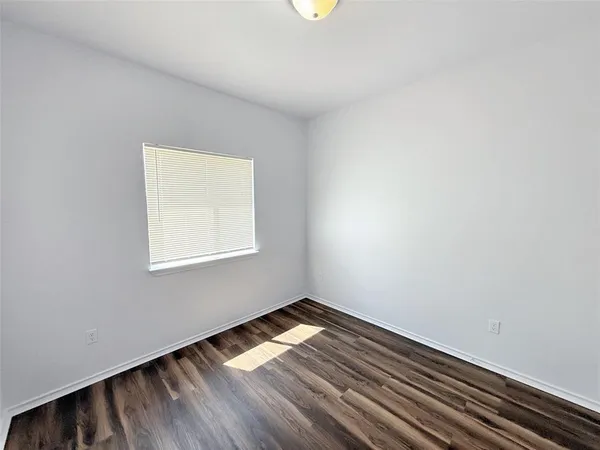 a room with a wooden floor and a window