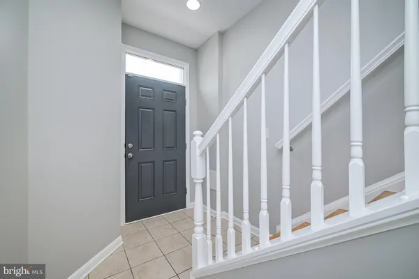 a view of staircase with railing and white walls
