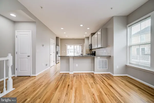 a view of a kitchen with wooden floor and electronic appliances