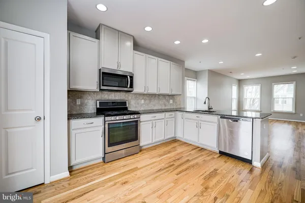 a kitchen with a refrigerator stove top oven and sink
