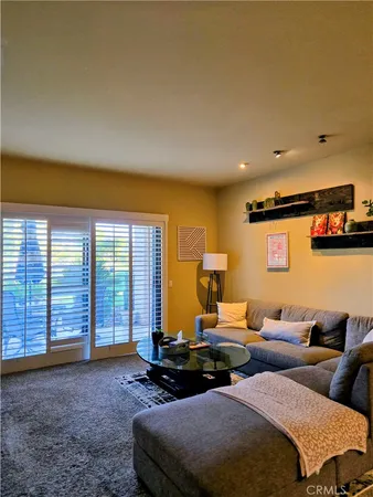 a living room with furniture a flat screen tv and a large window