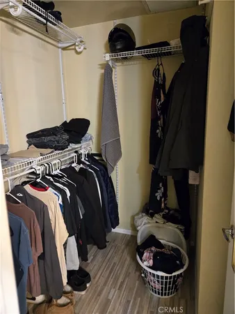 a view of walk in closet with clothes and shoes