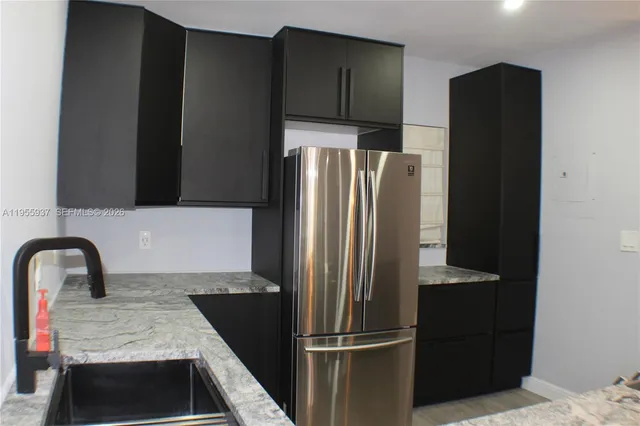 a kitchen with a refrigerator and a sink