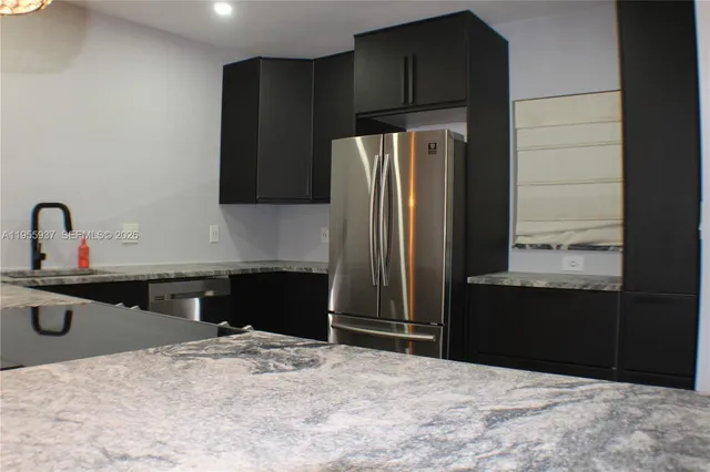 a kitchen with a refrigerator and a sink
