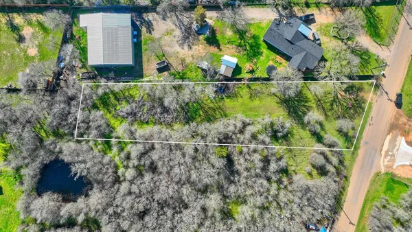 an aerial view of a house with a yard and lake view