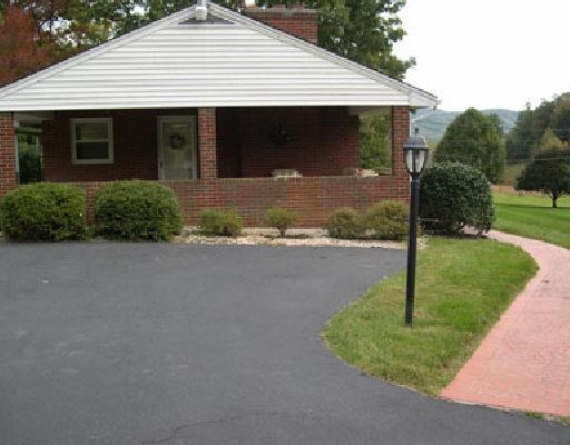 2246 Blue Ridge Springs Road Blue Ridge, VA 24064 - Photo 2 of 5 a front view of a house with a yard and garage