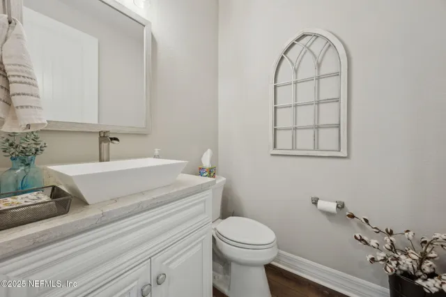 a front view of a house with garden and trees