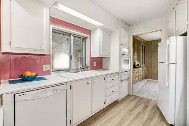 a kitchen with white cabinets and a refrigerator