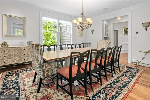 a kitchen with stainless steel appliances granite countertop a stove a sink a refrigerator and white cabinets with wooden floor