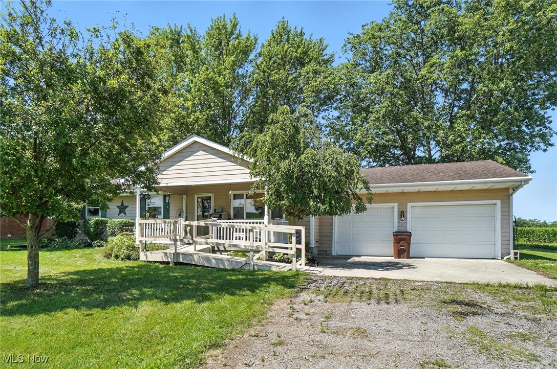 2045 Dutch Hollow Road Lima, OH 45807 - Photo 2 of 33 View of front of home with driveway, a garage, covered porch, a front yard, and a shingled roof