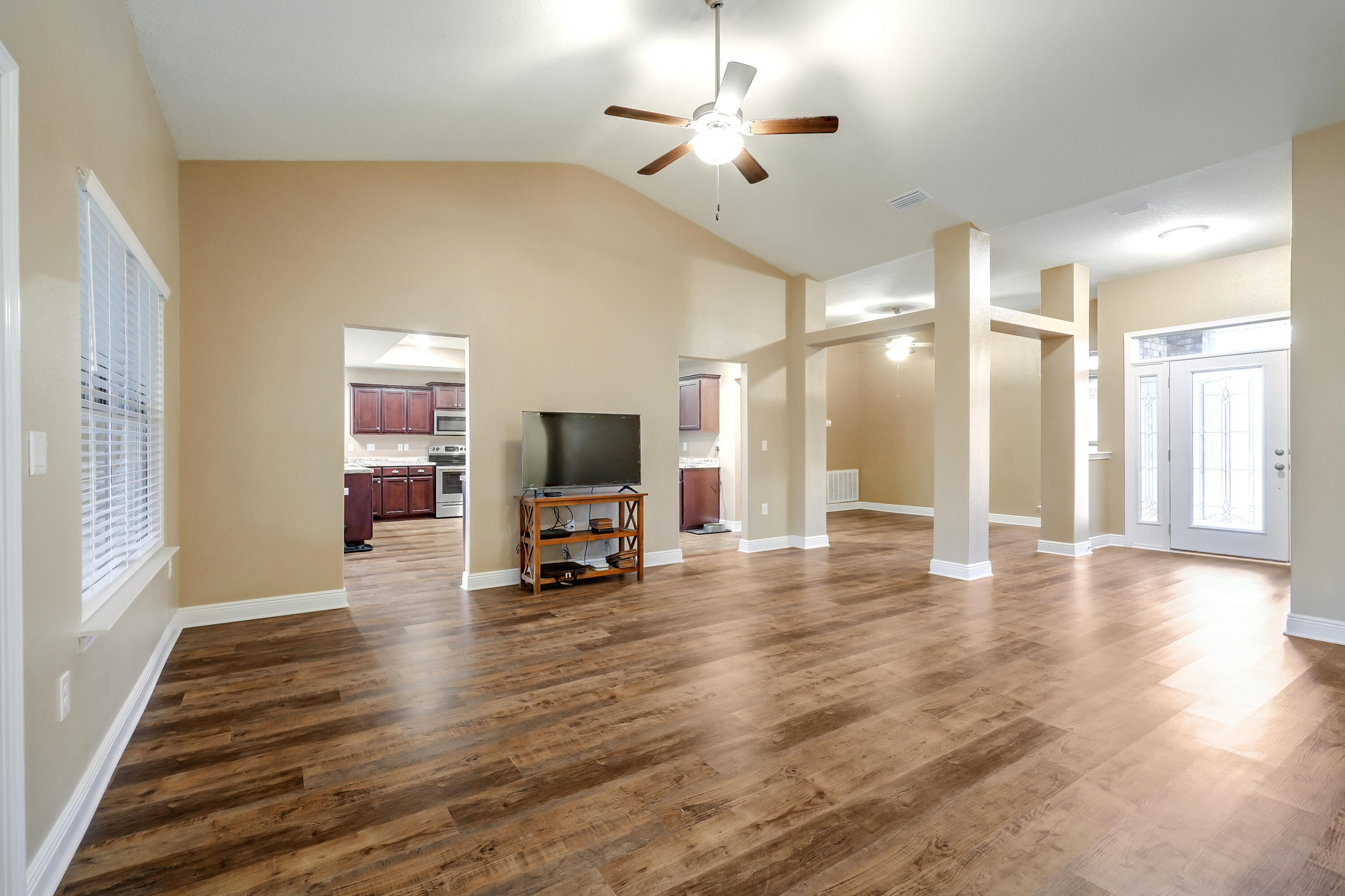5726 Marigold Loop Crestview, FL 32539 - Photo 8 of 38 a view of a livingroom with a flat screen tv wooden floor and a ceiling fan