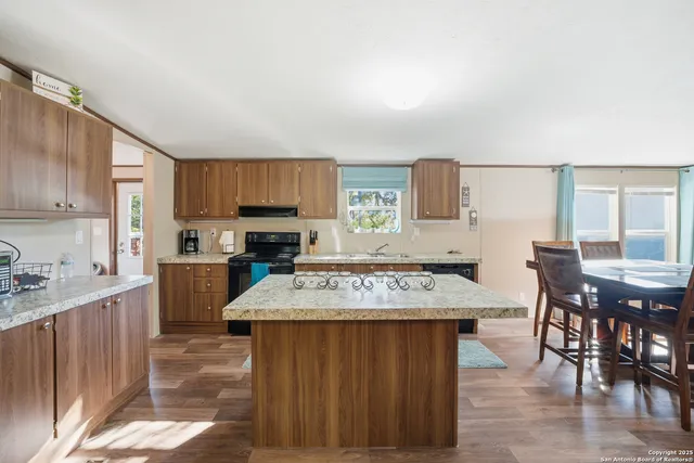 a kitchen with a stove a sink a dining table and chairs