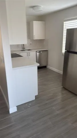 a view of kitchen with granite countertop cabinets and wooden floor