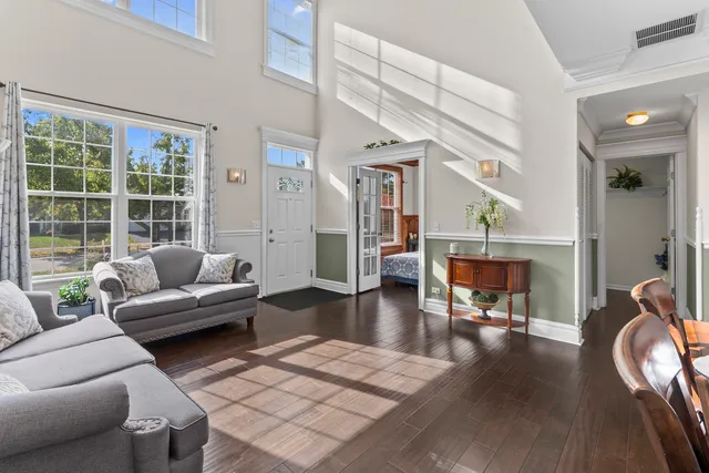 a living room with couches and a night stand with wooden floor