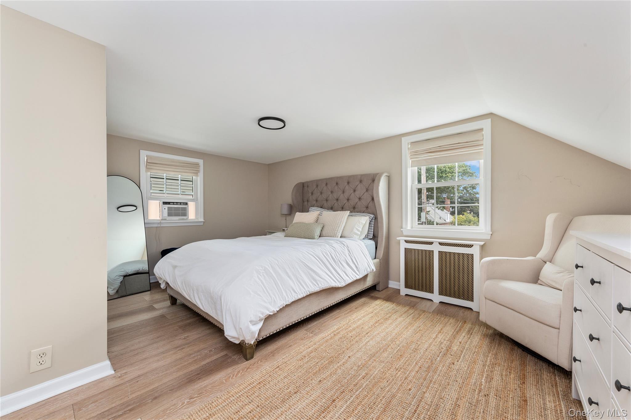 11 Dewitt Street Valley Stream, NY 11580 - Photo 12 of 21 Bedroom with radiator, light wood finished floors, and lofted ceiling