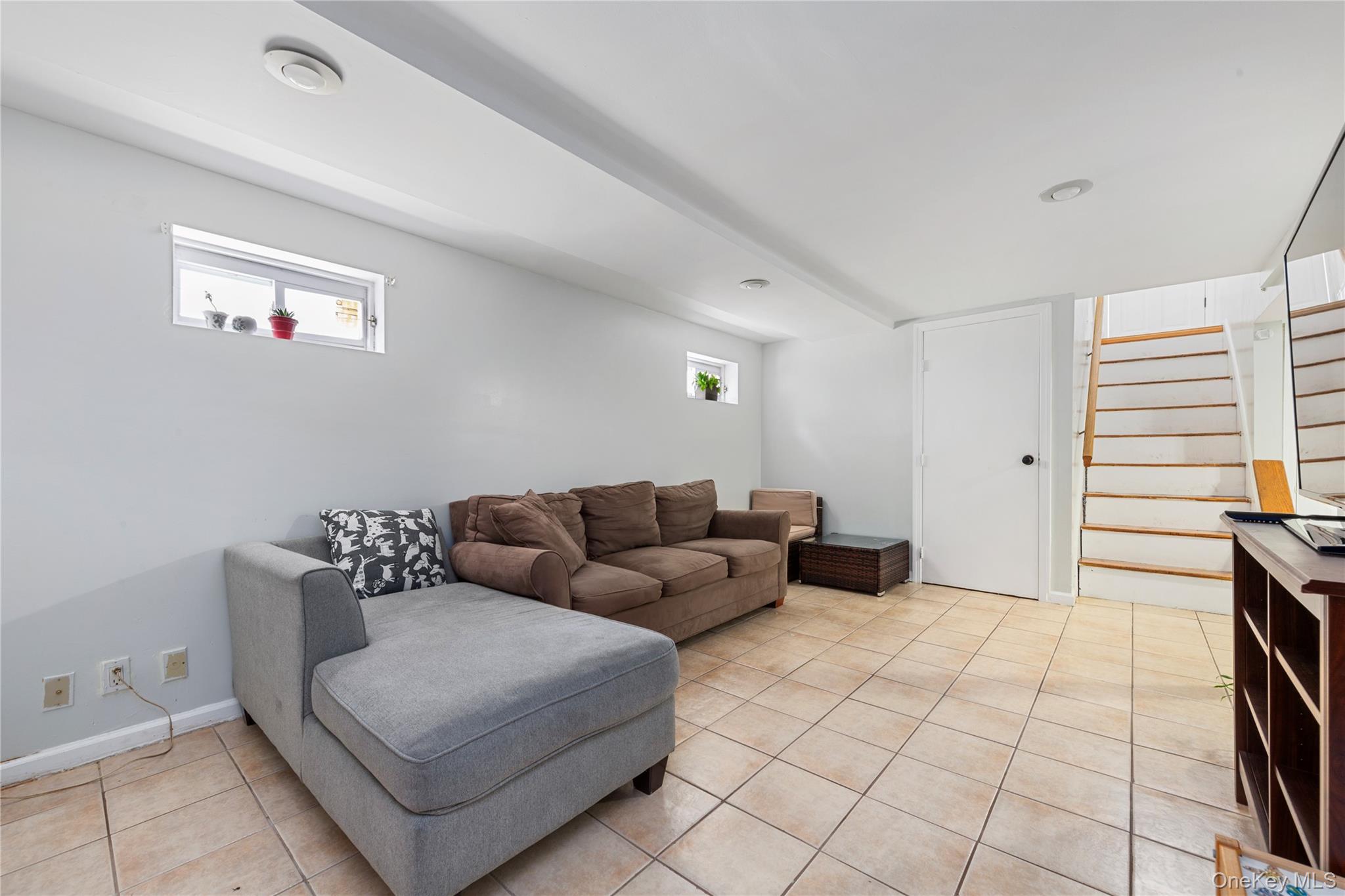 11 Dewitt Street Valley Stream, NY 11580 - Photo 16 of 21 Living area featuring light tile patterned flooring and stairway