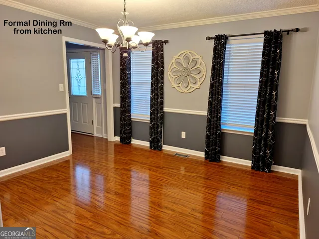 a view of a room with wooden floor and chandelier