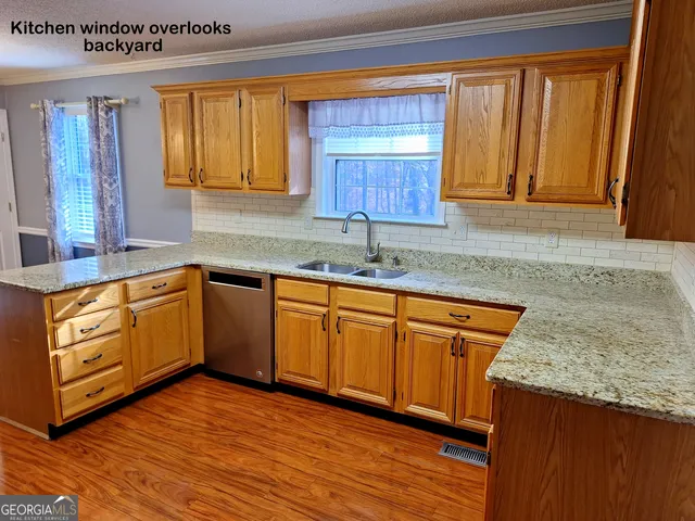 a kitchen with stainless steel appliances granite countertop wooden floors and granite counter tops
