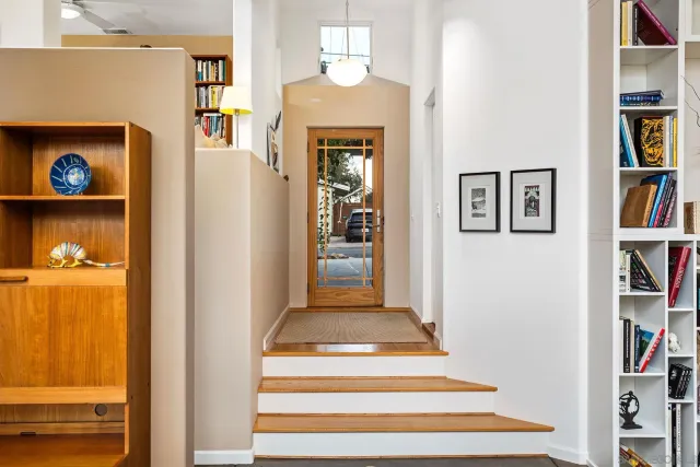 a view of a bedroom with wooden floor and stairs