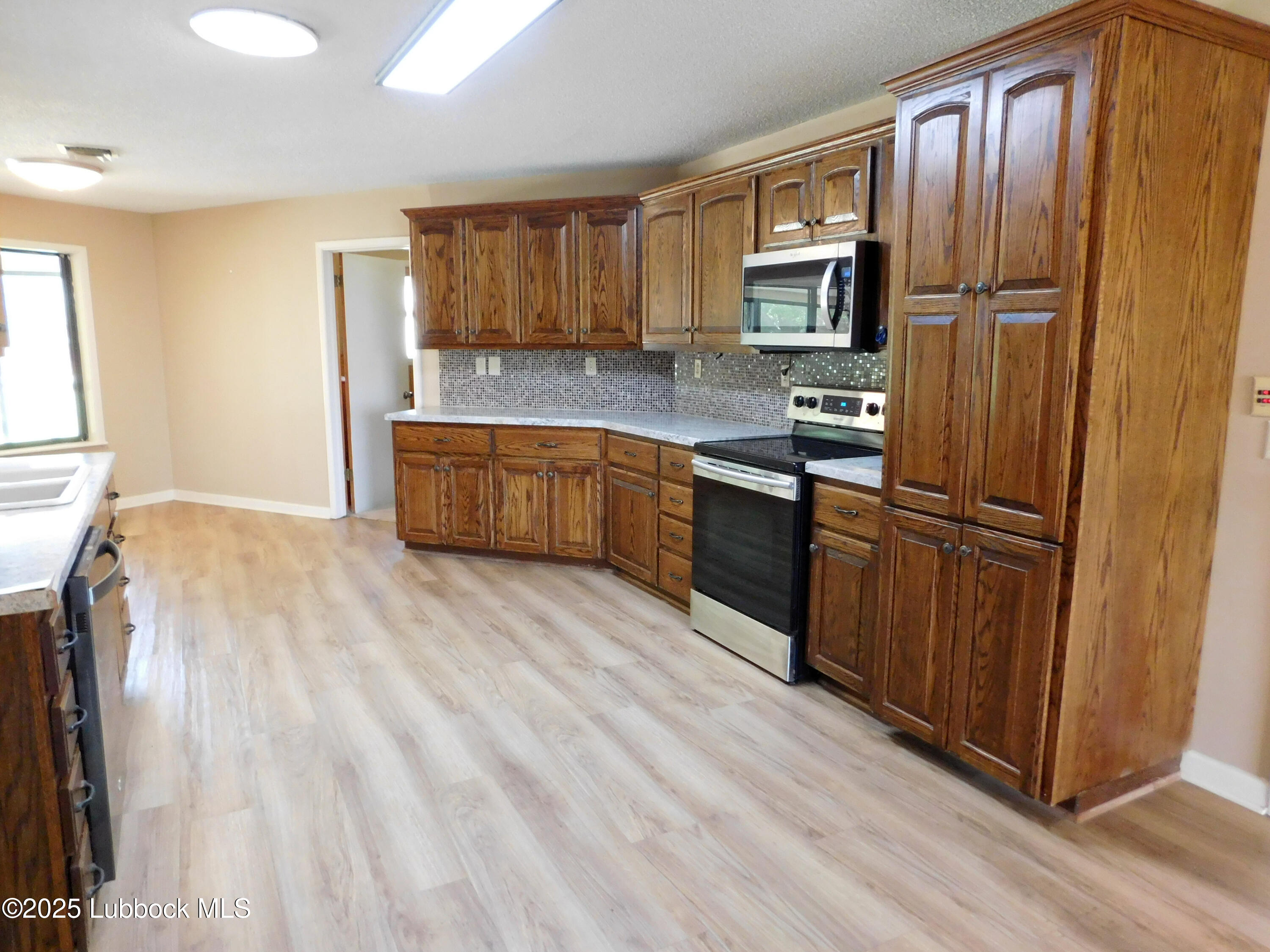 1925 Highway 70 Muleshoe, TX 79347 - Photo 11 of 49 a kitchen with stainless steel appliances granite countertop a refrigerator microwave and sink