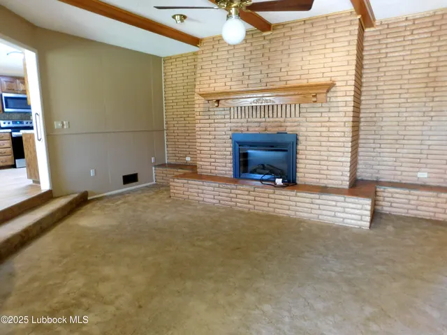 a view of a livingroom with wooden floor and a fireplace