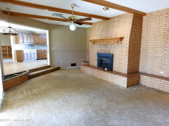 a view of a livingroom with a fireplace and window