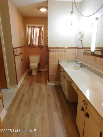 a spacious bathroom with a sink a mirror and a toilet