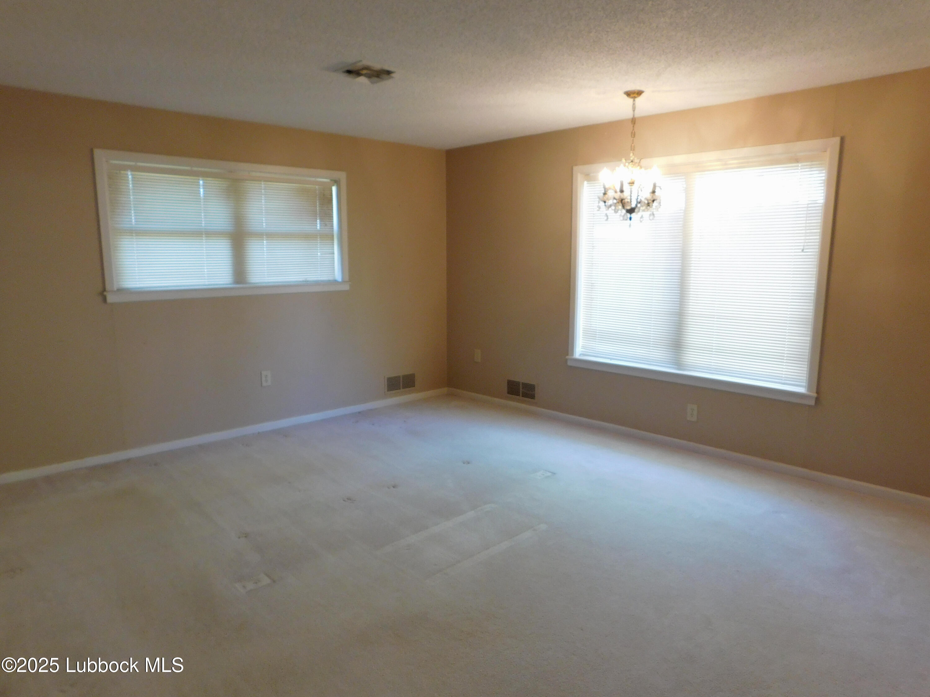 1925 Highway 70 Muleshoe, TX 79347 - Photo 32 of 49 an empty room with windows and chandelier fan