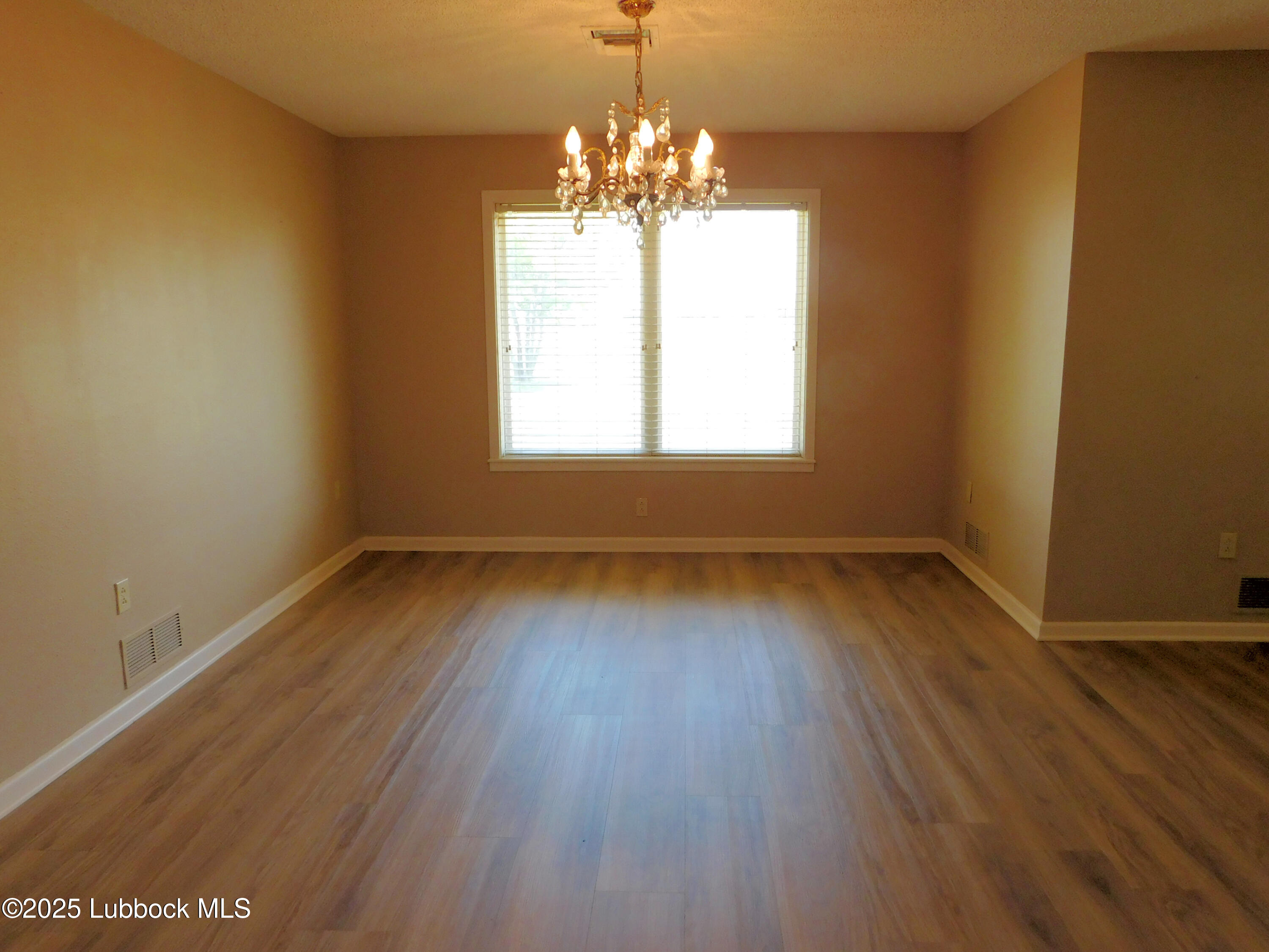 1925 Highway 70 Muleshoe, TX 79347 - Photo 7 of 49 an empty room with wooden floor and windows