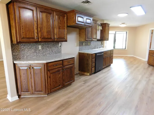 a kitchen with stainless steel appliances granite countertop wooden cabinets a sink and dishwasher