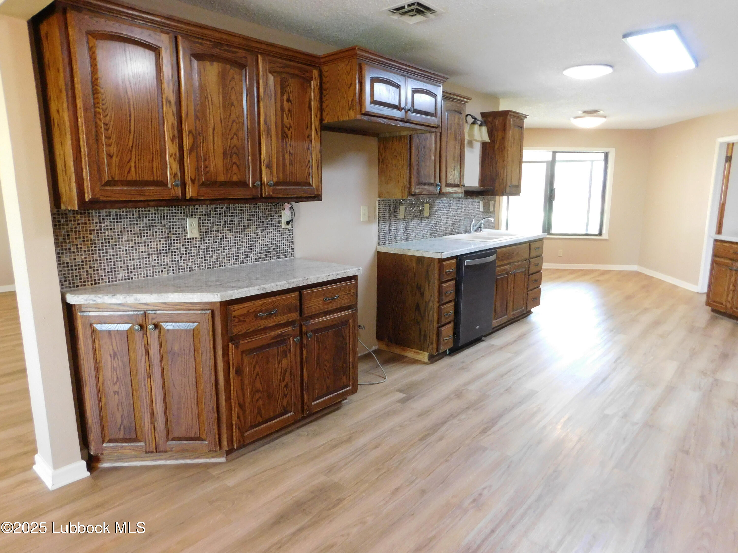 1925 Highway 70 Muleshoe, TX 79347 - Photo 10 of 49 a kitchen with stainless steel appliances granite countertop wooden cabinets a sink and dishwasher
