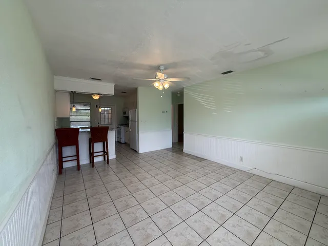 a view of a livingroom and a kitchen with furniture and chandelier