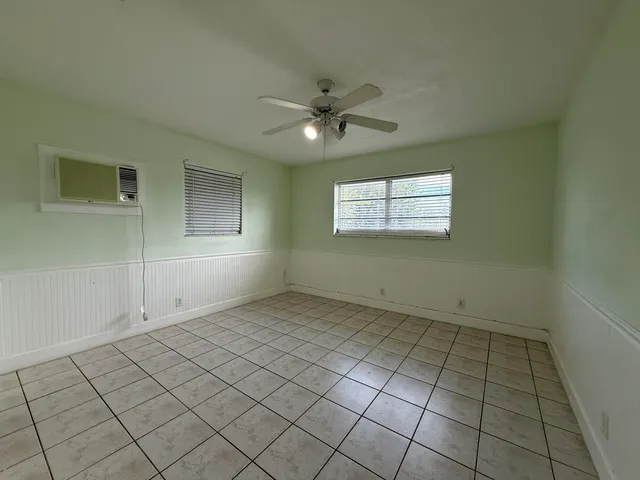 an empty room with windows and fan