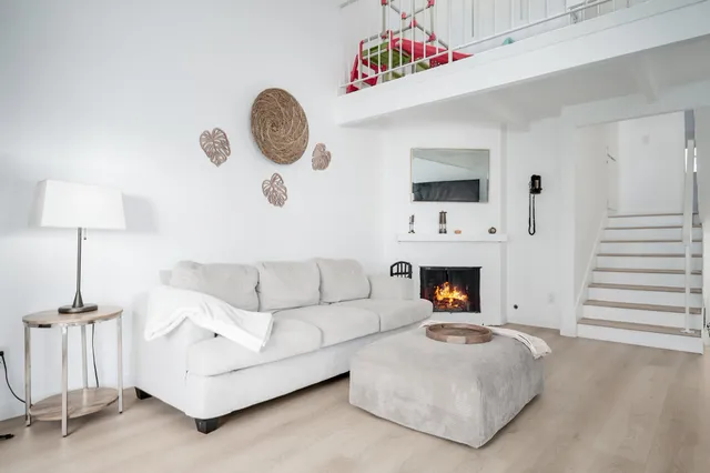 a living room with furniture a fireplace and a large window