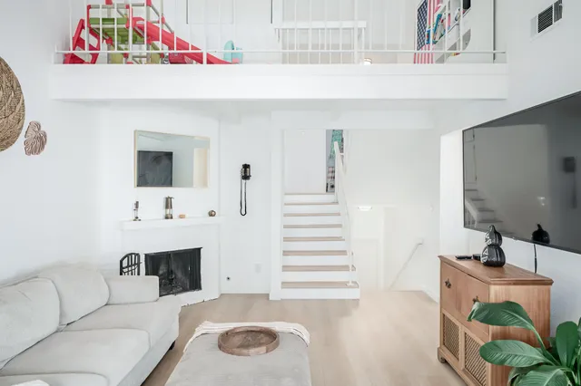 a bedroom with a bed and a potted plant on the dresser