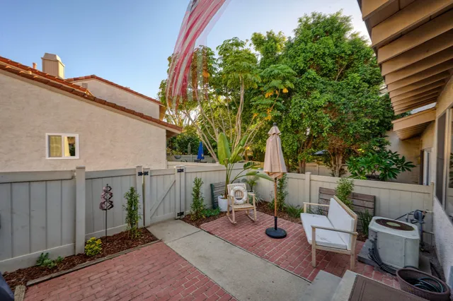 a view of pool with lawn chairs and large trees