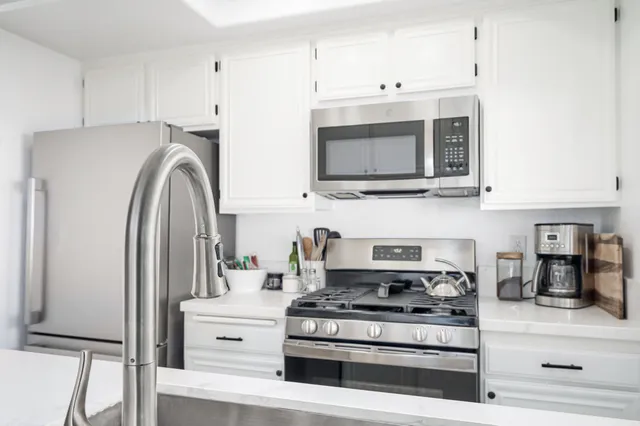 a white stove top oven sitting inside of a kitchen