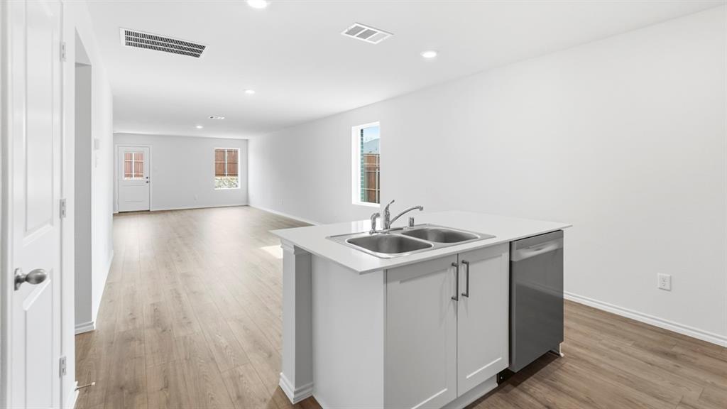 3519 Spring Time Street Forney, TX 75126 - Photo 22 of 37 Kitchen island with a double basin stainless steel sink and a stainless steel dishwasher